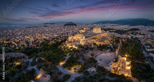 Aerial view of the illuminated skyline and ancient ruins at the Acropolis of Athens, Greece, with Parthenon Temple and Odeon of Herode theatre during evening