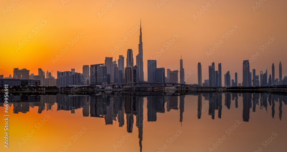 The urban skyline of Dubai Business bay with reflections of the modern skyscrapers in the water during sunset, UAE