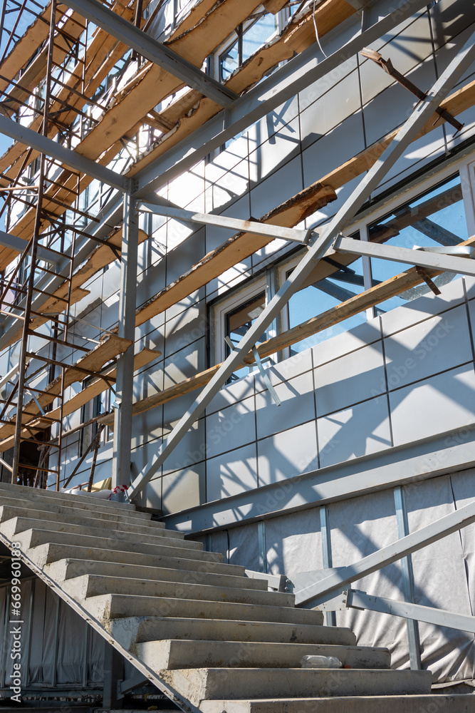 Construction of a building using scaffolding. Facade restoration work. Fragment of scaffolding and stairs