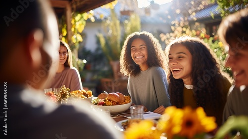 Cheerful companions getting a charge out of thanksgiving lunch at eating table photo