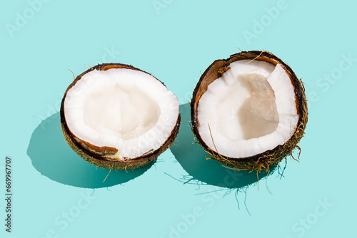 Halved coconut against blue background photo