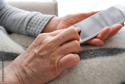 スマートフォンを操作する高齢女性の手元