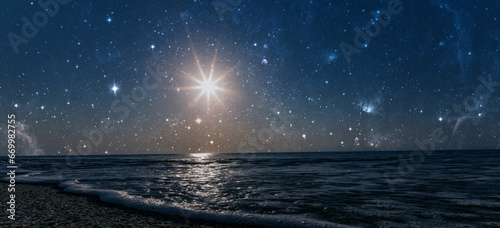 Fototapeta Naklejka Na Ścianę i Meble -  a star shines in the night sky over the sea on the holiday of Christmas