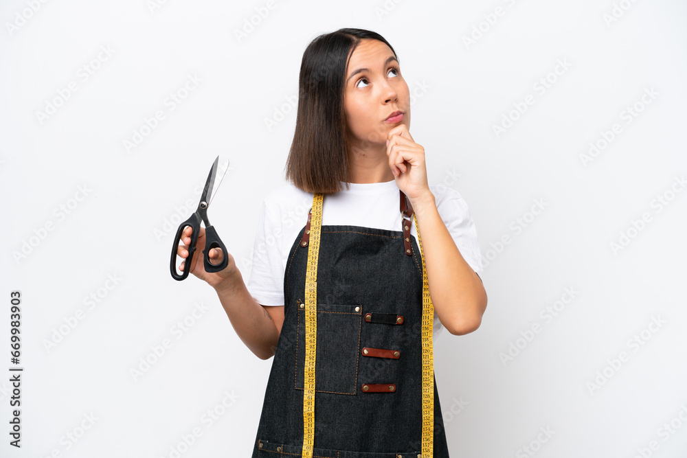Young seamstress woman isolated on white background having doubts Young seamstress woman isolated on white background having doubts