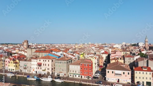 Aerial flight over the old port city of Chioggia with red roofs, narrow streets and lots of canals.