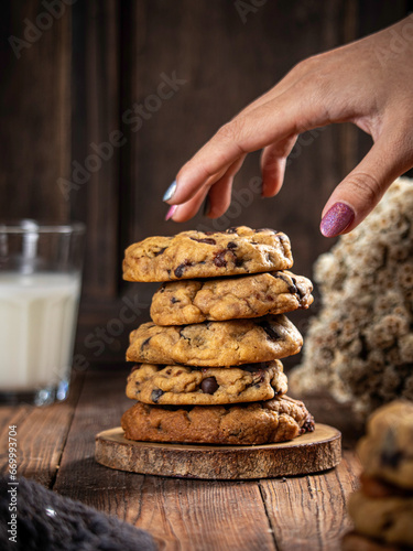 Cookies are stacked neatly on a wooden placemat, isolated with a wooden table background.