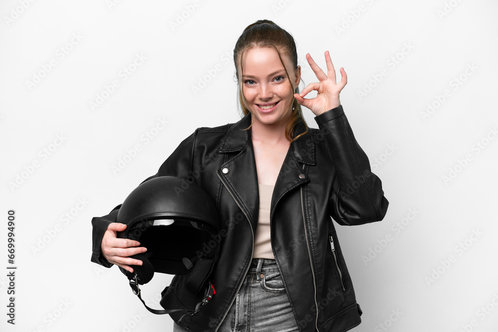 Young caucasian girl with a motorcycle helmet isolated on white background showing ok sign with fingers