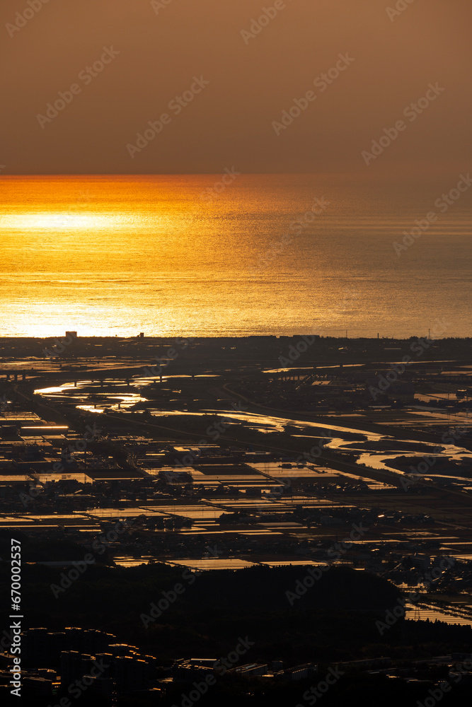 Naklejka premium 日本海に沈む夕陽と手取川扇状地