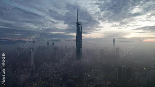 Establishing aerial cinematic b-roll shot of sunrise at Kuala Lumpur city skyline with highest building in Asia photo