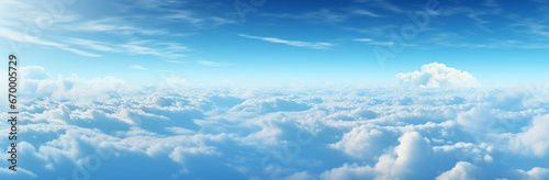 Blue sky background with tiny clouds. Panoramic view. Beautiful aerial view above clouds with blue sky. Beautiful aerial view above clouds on a sunny day.