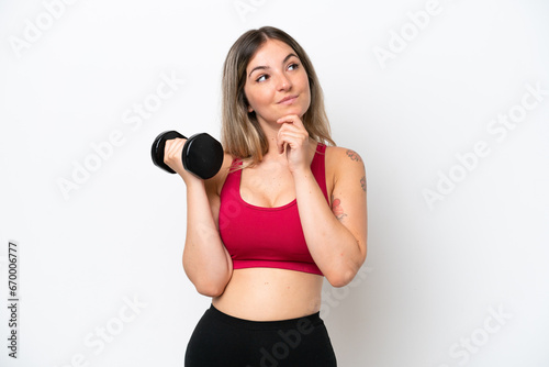 Young sport Rumanian woman making weightlifting isolated on white background and looking up