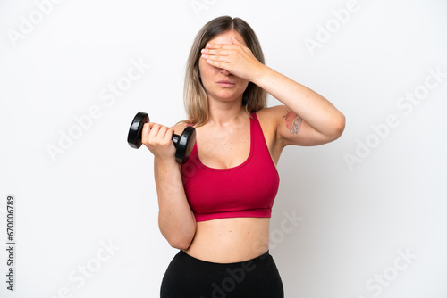 Young sport Rumanian woman making weightlifting isolated on white background covering eyes by hands. Do not want to see something