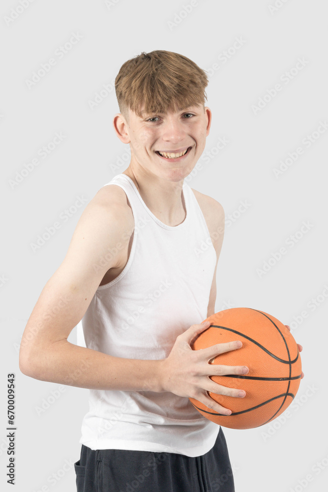 Teenage boy playing basketball