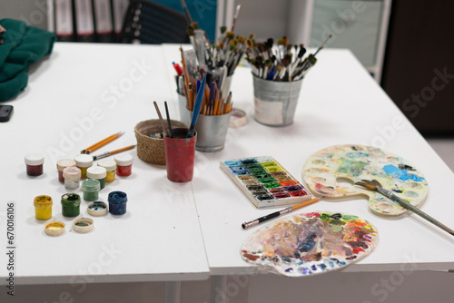 artist's workplace in the studio with different paints and brushes