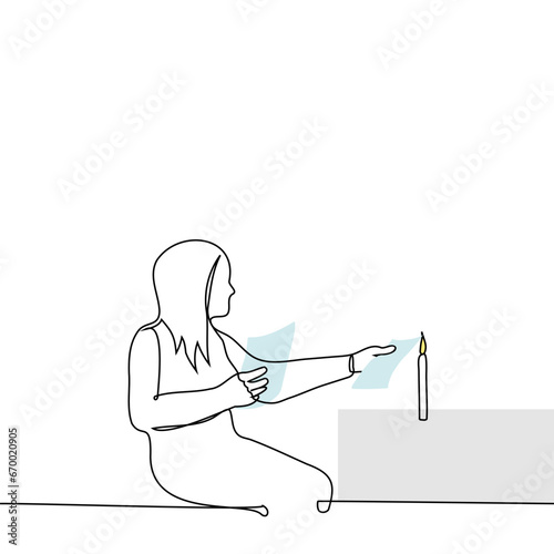 woman sitting burning paper sheets from a burning candle - one line art vector. concept burn letters or incriminating documents