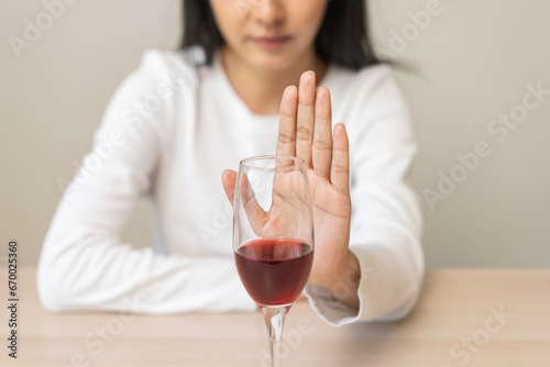 Alcoholism, depressed asian young woman hand refuse red wine or alcoholic beverage, female drinking whiskey and quit booze. Treatment of alcohol addiction, having suffered abuse problem alcoholism. photo