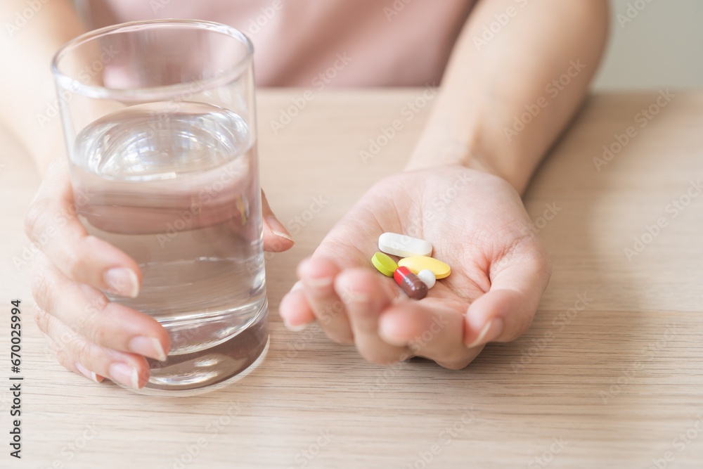 Sick, asian young woman, girl hand holding pill capsule, painkiller medicine from stomach pain, head ache, pain for treatment, take drug or vitamin and glass of water at home, pharmacy and health care Sick, asian young woman, girl hand holding pill capsule, painkiller medicine from stomach pain, head ache, pain for treatment, take drug or vitamin and glass of water at home, pharmacy and health care