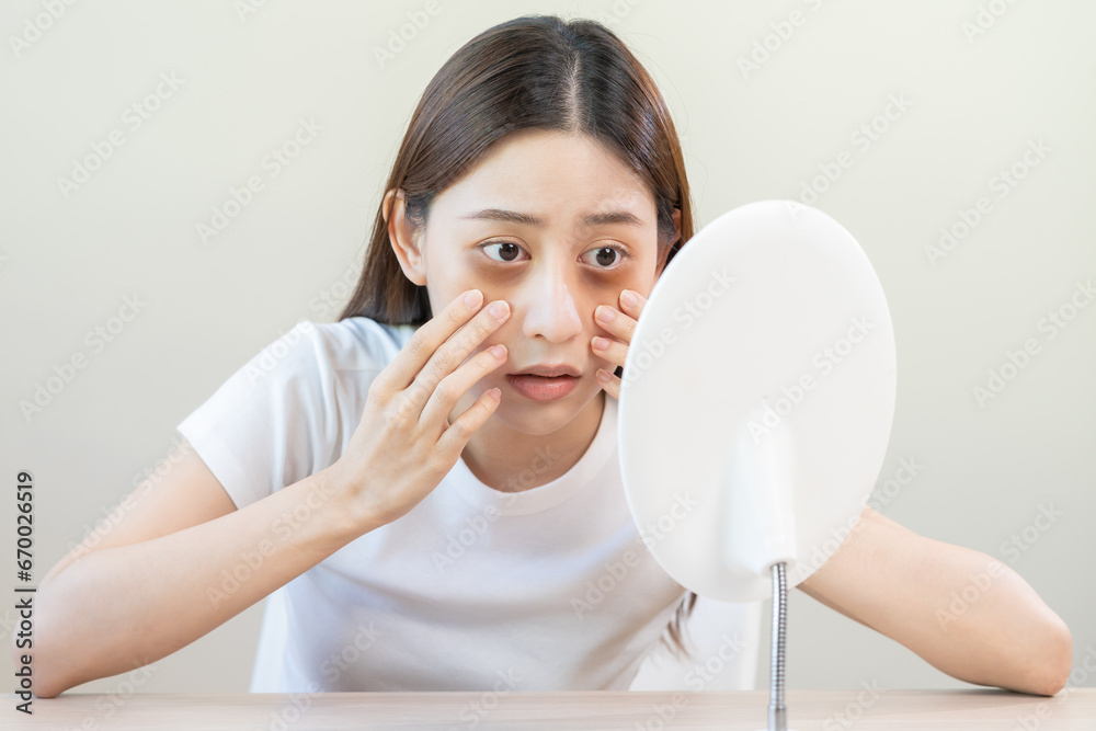 Bored, insomnia asian young woman, girl looking at mirror hand touching under eyes with problem of black circles or panda puffy, swollen and wrinkle on face. Sleepless, sleepy healthcare person. Bored, insomnia asian young woman, girl looking at mirror hand touching under eyes with problem of black circles or panda puffy, swollen and wrinkle on face. Sleepless, sleepy healthcare person.