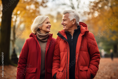 Portrait Of Loving Senior Couple Enjoying Autumn Or Winter Walk Through Park Together