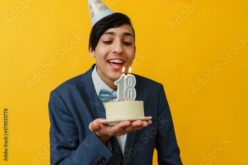 Happy man blowing candle on 18th birthday photo