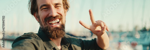 Fotografiet Closeup portrait of a smiling man with a beard chatting on the embankment, on a yacht background