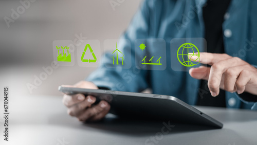 Businessman using tablet with reduce CO2 emissions carbon global symbol on green background for climate change to limit global warming and sustainable development and green business concept.