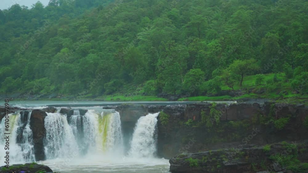 Slow mo shot of Gira waterfall flowing in full force from above the cliff at Waghai on the way to Saputara hill station in Gujarat, India. Waterfall of Sahyadri's during the monsoon season in India. Slow mo shot of Gira waterfall flowing in full force from above the cliff at Waghai on the way to Saputara hill station in Gujarat, India. Waterfall of Sahyadri's during the monsoon season in India.