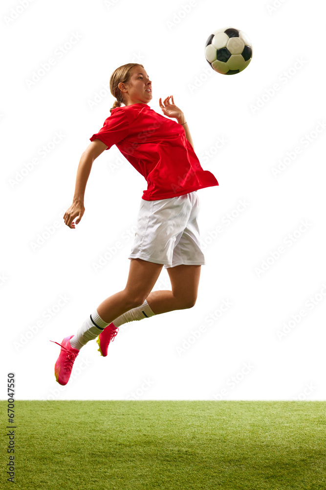 Full-length image of young girl, football player hitting ball with breast in a jump isolated on white background. Concept of sport, competition, action, success, motivation. Copy space for ad