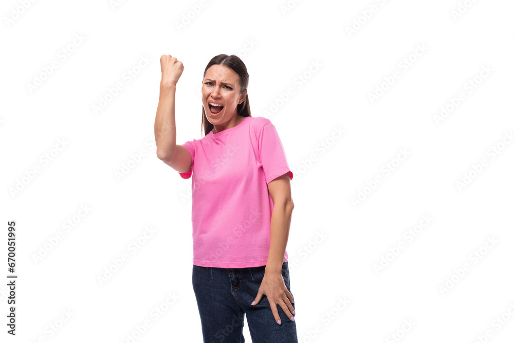 young positive good-looking woman with black hair dressed in a pink t-shirt rejoices in winning young positive good-looking woman with black hair dressed in a pink t-shirt rejoices in winning