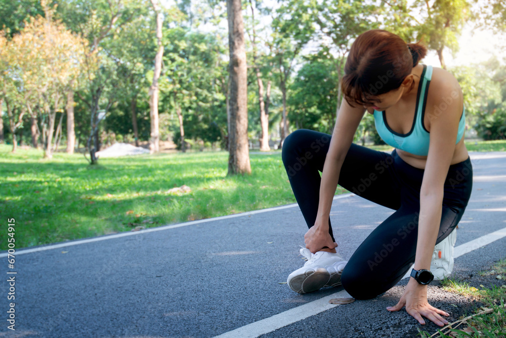 Asian female joggers pain and after running in the public park, care and treatment