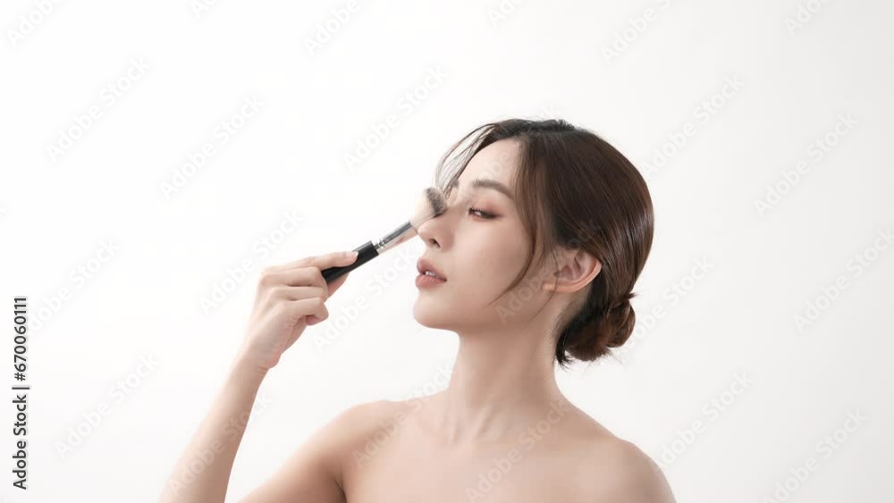 Beauty concept of 4k Resolution. Asian girls brushing their cheeks with a powder foundation. Beauty concept of 4k Resolution. Asian girls brushing their cheeks with a powder foundation.