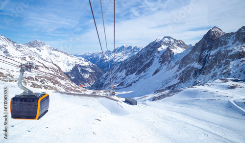 Canvastavla panoramic view of Alps mountain snowy range with skiing trails and cable car in