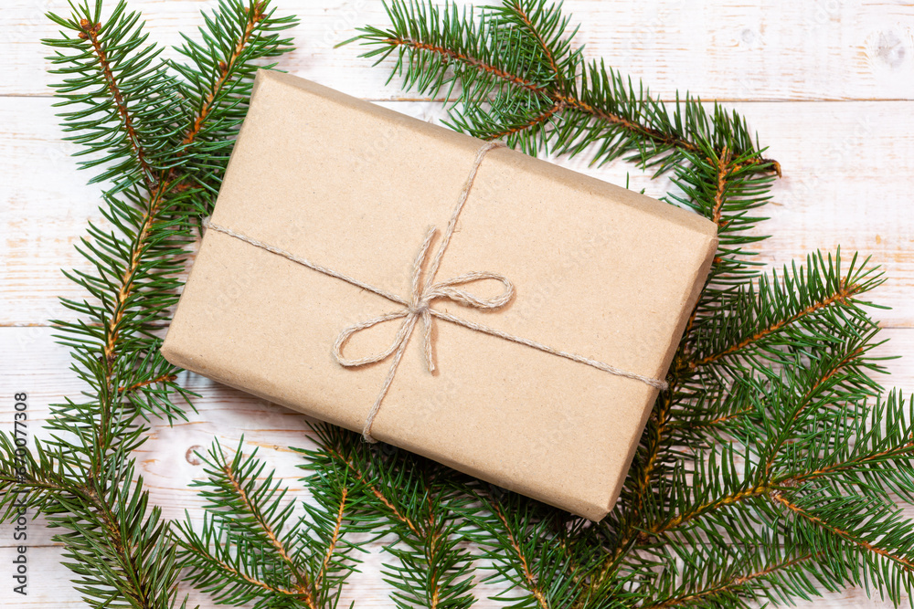 Christmas flatlay - fir branches and gift box on a white wood table. Flat layout, top view composition Christmas flatlay - fir branches and gift box on a white wood table. Flat layout, top view composition
