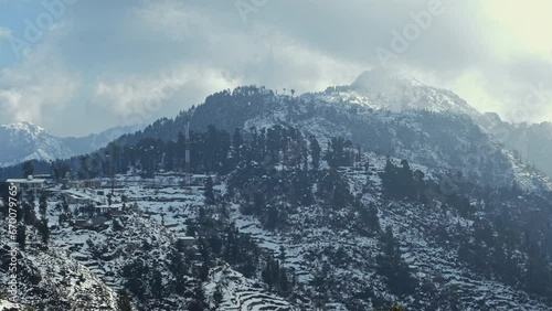 Aerial view of beautiful snow-covered mountains during winters in the Himalayan region of Uttarakhand. Trees and hills are covered in snow. Snowfall in Dhanaulti. Snowcapped forest valley in India. 4K photo