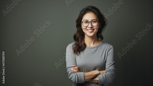 Portrait of a smiling middle aged asian woman in eyeglasses looking at camera.
