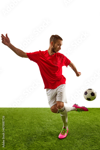Professional soccer player looks confident in red sportwear and boots training, playing isolated over white studio background.