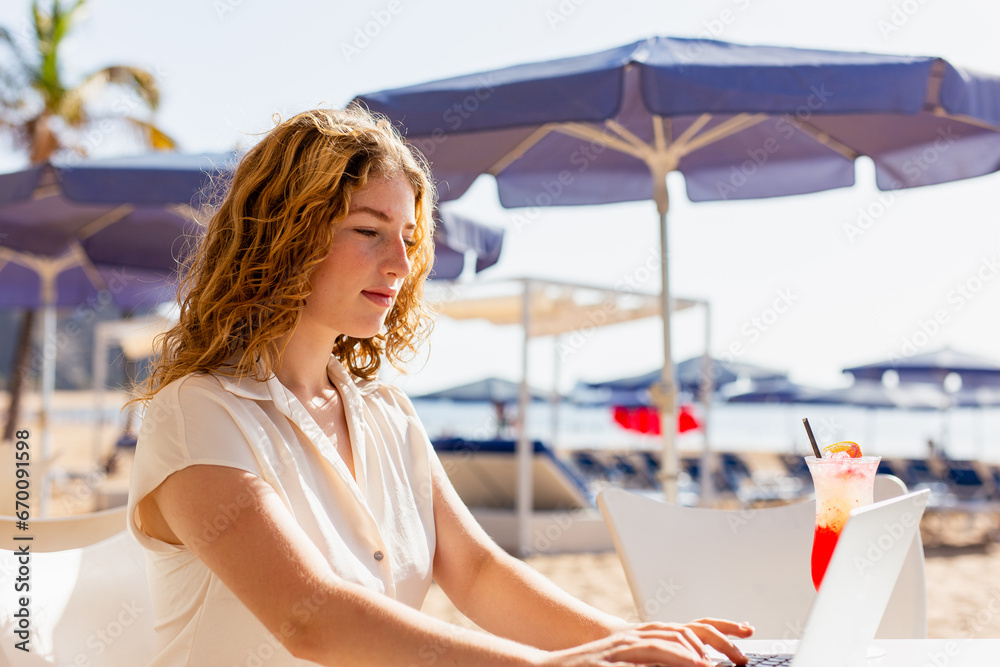 Woman teleworker using laptop on terrace, surfing web, searching for business data