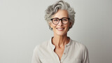 Portrait of beautiful older businesswoman in eyeglasses looking at camera.