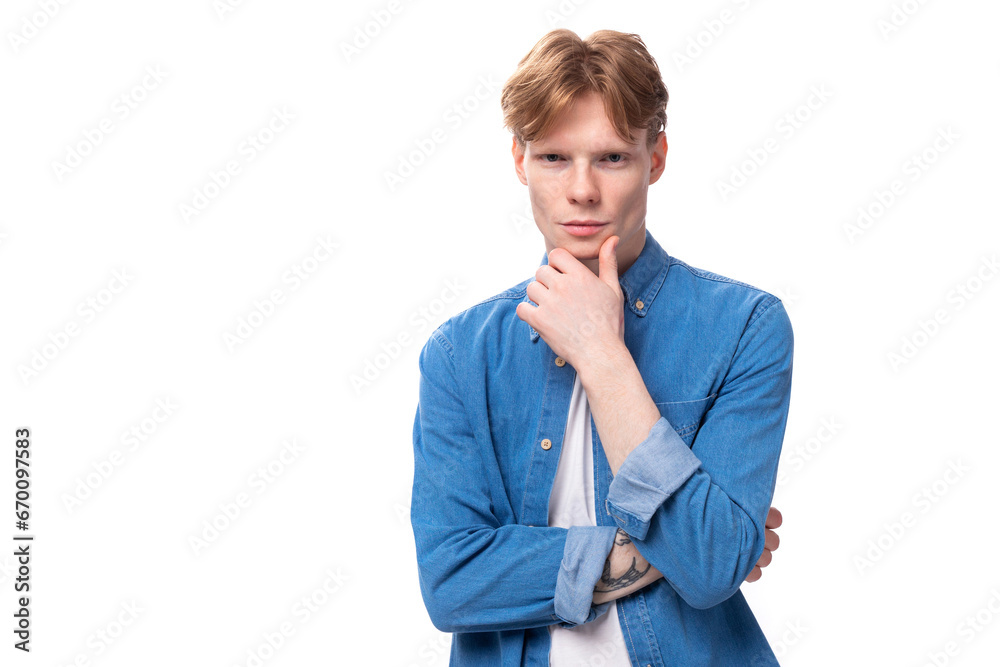 portrait of a pensive caucasian red-haired guy in a denim blue shirt portrait of a pensive caucasian red-haired guy in a denim blue shirt