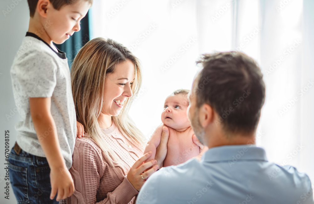 family on bedroom with his newborn baby son family on bedroom with his newborn baby son