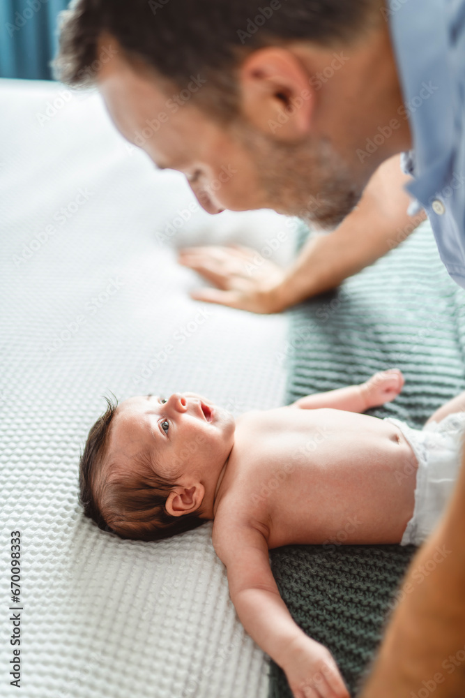 father on bedroom with his newborn baby son father on bedroom with his newborn baby son