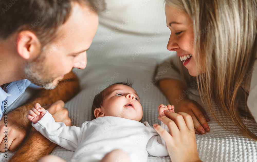 father and mother on bedroom with his newborn baby son