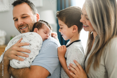 family on bedroom with his newborn baby son photo