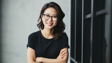 Portrait of a smiling asian businesswoman in eyeglasses on black background.