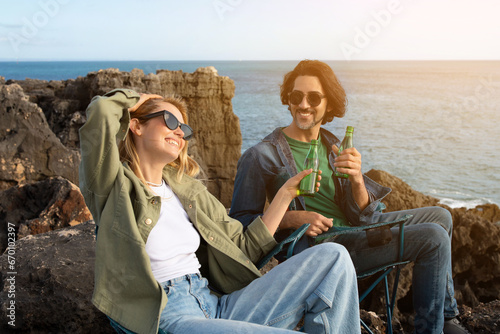 Two Friends Man And Woman Relaxing On Rocks Near Ocean Shore © Prostock-studio