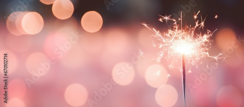 A close-up of a Bengal light on a pink blurred background. Celebration of the new year and Christmas. Party accessory