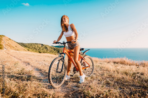 Sporty attractive woman with mountain bicycle in outdoor. Lifestyle with young lady. photo