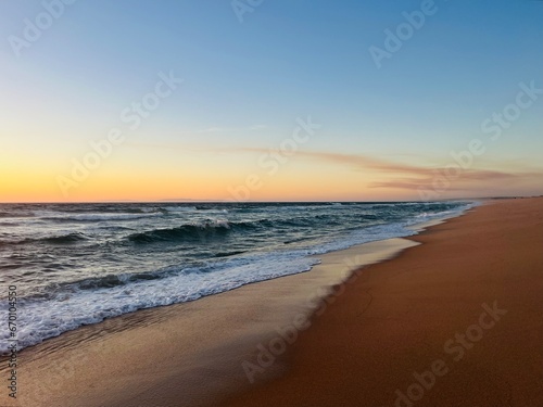 Orange sea horizon, sandy coastline, evening seascape reflection, pastel colors