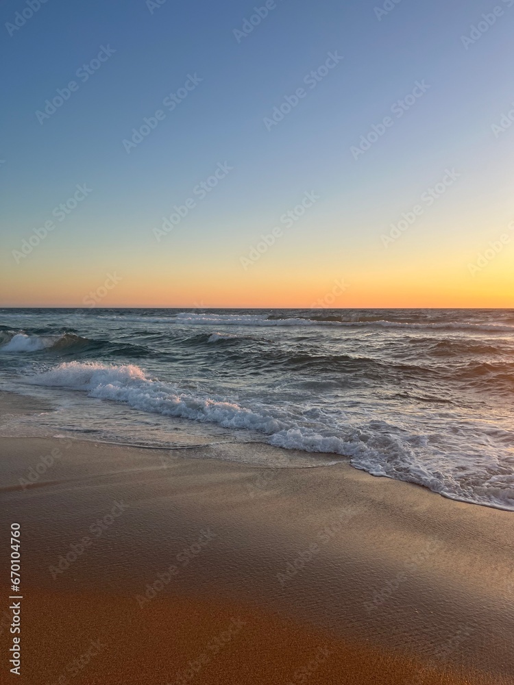 Orange sea horizon, sandy coastline, evening seascape reflection, pastel colors