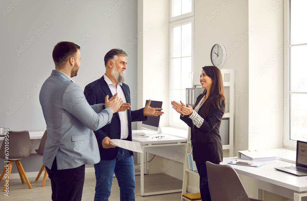 Business people applauding their successful colleague in office. Business team congratulating coworker, expressing gratitude, recognition, appreciation. Good job result, work achievement concept - obrazy, fototapety, plakaty 
